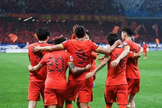 10月15日晚，張玉寧（9號(hào)）進(jìn)球后與隊(duì)友擁抱慶祝。新華社記者 李紫恒攝