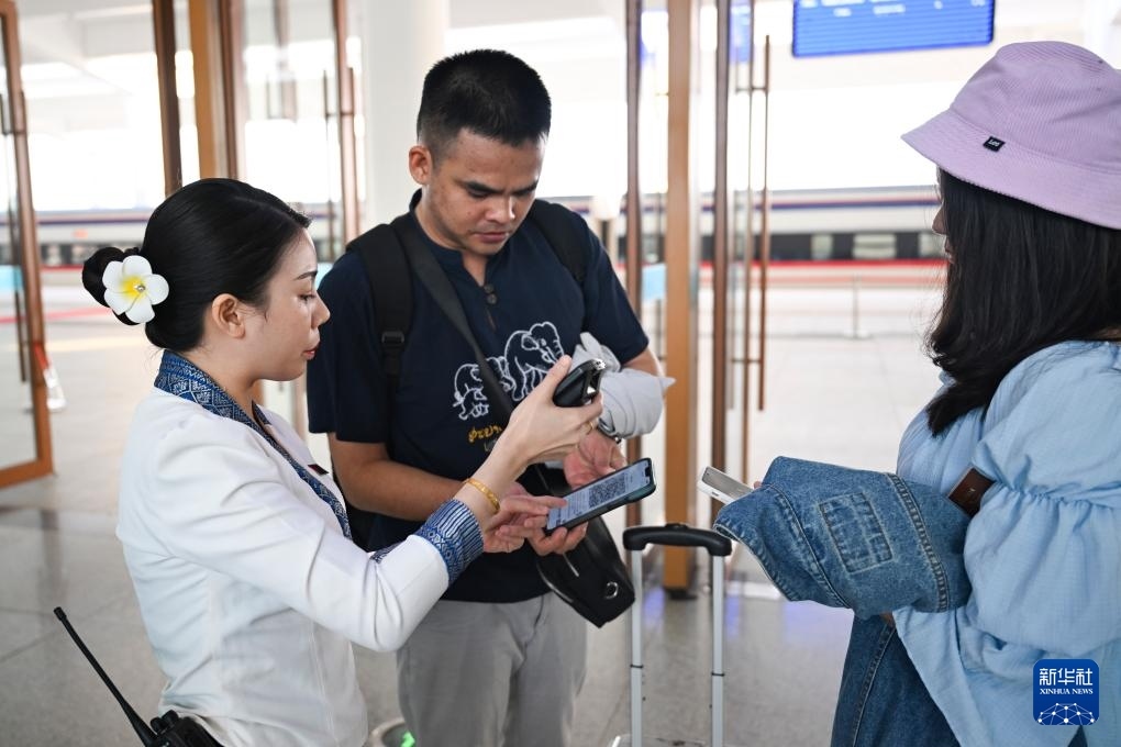 10月12日，在老撾萬象中老鐵路萬象站，工作人員檢驗乘客車票。新華社記者 程一恒 攝