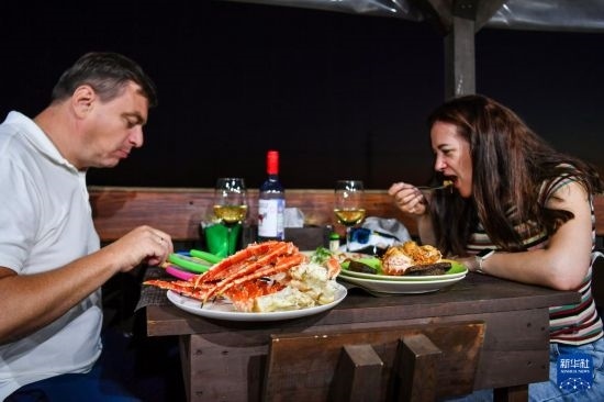 9月2日，食客們在俄羅斯符拉迪沃斯托克的一家餐館品嘗帝王蟹。新華社記者 曹陽 攝