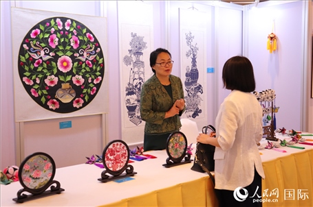 青海非遺文化傳承人向嘉賓介紹展品。人民網(wǎng)實(shí)習(xí)生姚欣可攝