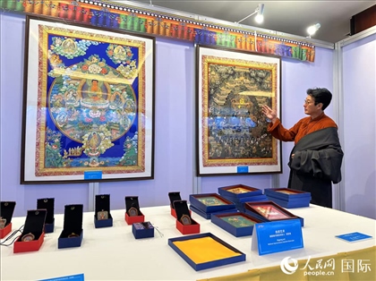 熱貢藝術(shù)國(guó)家級(jí)代表性傳承人夏吾角向嘉賓介紹作品。人民網(wǎng)記者 簡(jiǎn)承淵攝