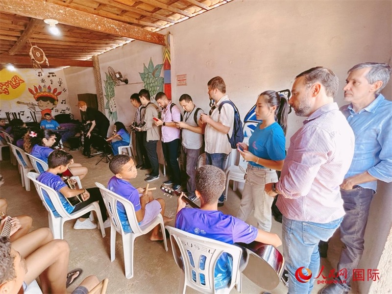  受益于中國企業(yè)的“青少年成長”項目，700多名當?shù)厍嗌倌甑囊魳泛妥闱驂粝氩迳狭顺岚?。圖為聯(lián)合采訪團正在采訪參加音樂培訓的孩子們。 人民網(wǎng)記者 陳一鳴攝