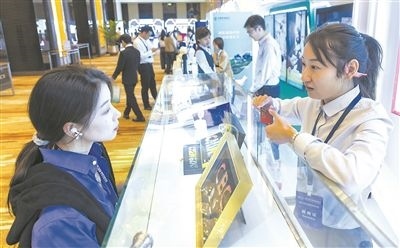 在北京麗澤商務(wù)區(qū)，工作人員（右一）介紹數(shù)字人民幣SIM卡硬錢包。新京報(bào)記者 陶冉攝