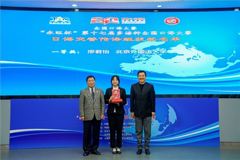 中國翻譯協(xié)會副會長中國外文局中東歐與中南亞傳播中心（人民畫報社）主任姜永鋼（右一）、原中國教育工會全國委員會巡視員白立文（左一）為獲得日語交傳組一等獎的北京外國語大學廖君怡頒獎（主辦方提供）