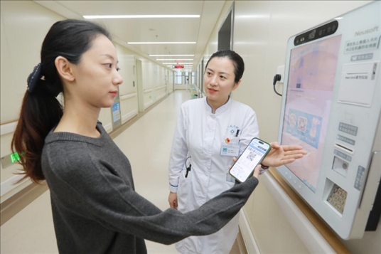 醫(yī)護人員引導患者在自助機前辦理自助入院手續(xù)。圖片來源：山東第一醫(yī)科大學第二附屬醫(yī)院