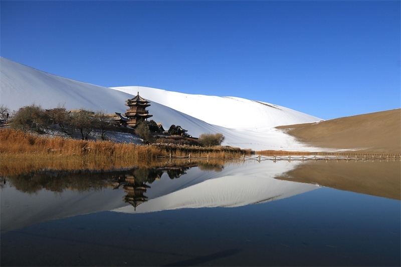鳴沙山月牙泉景區(qū)雪景。敦煌市委宣傳部供圖，張曉亮攝