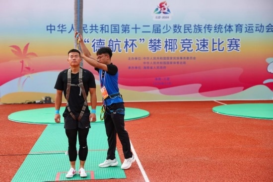 11月23日，工作人員為上海隊選手付樂樂（左）系安全繩。新華社記者 楊植森 攝