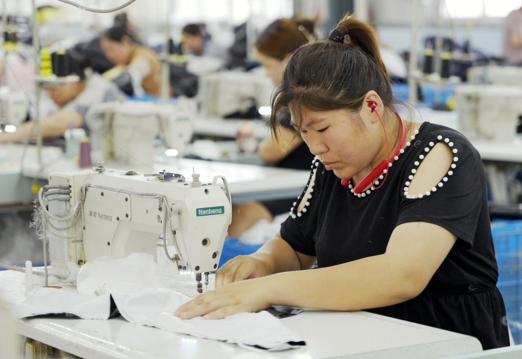 5月20日，村民在李寨村服裝加工廠內(nèi)忙碌。河南省周口市沈丘縣馮營鎮(zhèn)李寨村地處豫東平原。近年來，乘著脫貧攻堅與鄉(xiāng)村振興政策的東風，李寨村積極探索產(chǎn)業(yè)發(fā)展模式，通過“龍頭企業(yè)+村集體經(jīng)濟+農(nóng)戶”的方式，逐漸發(fā)展形成肉牛養(yǎng)殖、設施農(nóng)業(yè)、服裝加工、康養(yǎng)民宿等產(chǎn)業(yè)，以產(chǎn)業(yè)振興助力鄉(xiāng)村振興。新華社記者 李嘉南 攝