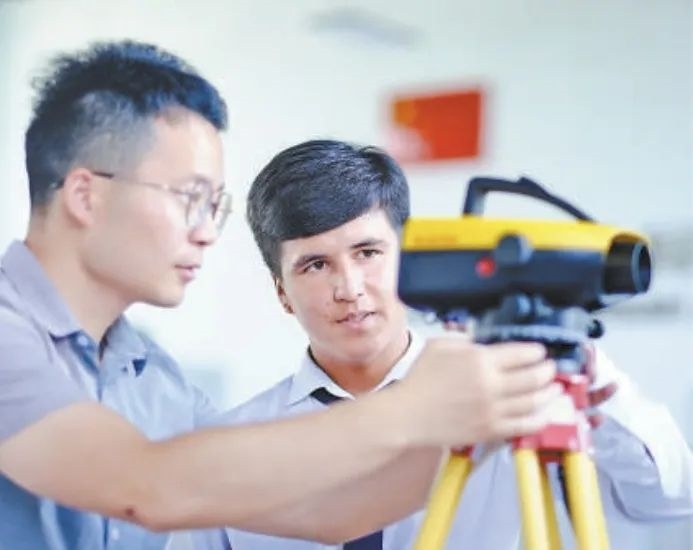 在塔吉克斯坦首都杜尚別的魯班工坊，來自天津城市建設(shè)管理職業(yè)技術(shù)學(xué)院的老師（左）為當(dāng)?shù)貙W(xué)生提供指導(dǎo)。新華社記者 鄭開君 攝