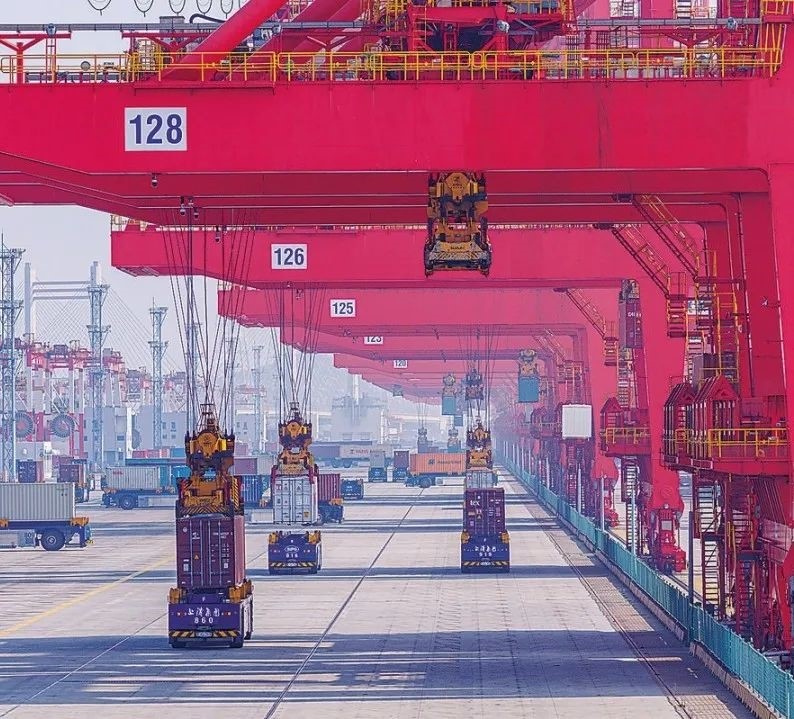 共建“一帶一路”國家在工作制度對接、技術(shù)標(biāo)準(zhǔn)協(xié)調(diào)、檢驗結(jié)果互認(rèn)等方面強(qiáng)化合作、統(tǒng)一標(biāo)準(zhǔn)，貿(mào)易自由化便利化水平不斷提升。上海洋山港海關(guān)對接共建國家進(jìn)出口貨物相關(guān)標(biāo)準(zhǔn)，推動通關(guān)一體化方式申報，提升通關(guān)效率。圖為無人駕駛的全自動導(dǎo)引車在洋山港穿梭往來，搬運(yùn)集裝箱。王初 攝