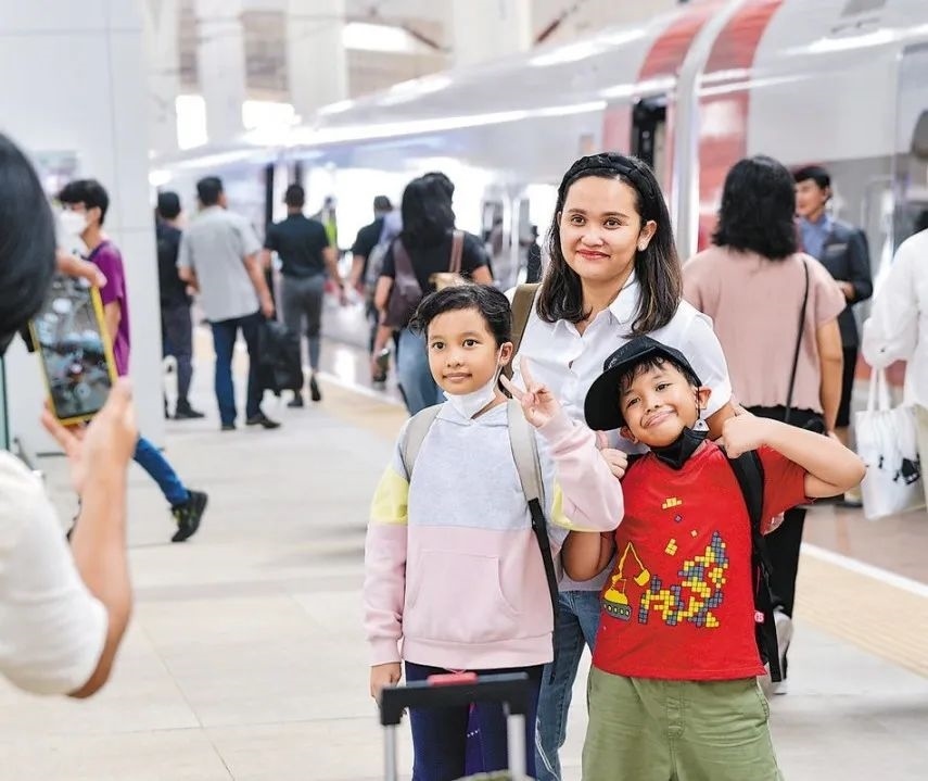 雅萬高鐵是我國在境外完成全過程勘察設(shè)計建設(shè)的首個高鐵項目，于去年10月17日正式開通運(yùn)營，是中印尼共建“一帶一路”合作的典范。圖為乘客在和雅萬高鐵動車組合影留念。新華社記者 徐欽 攝