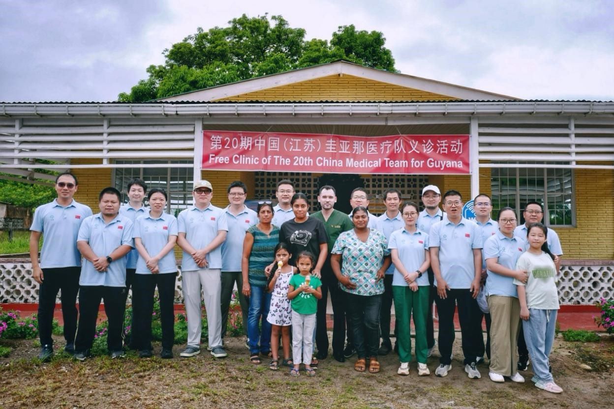 第20期中國（江蘇）援圭亞那醫(yī)療隊在圭偏遠(yuǎn)的林登高速社區(qū)開展義診后，與部分當(dāng)?shù)鼐用窈嫌啊?中國援圭醫(yī)療隊供圖