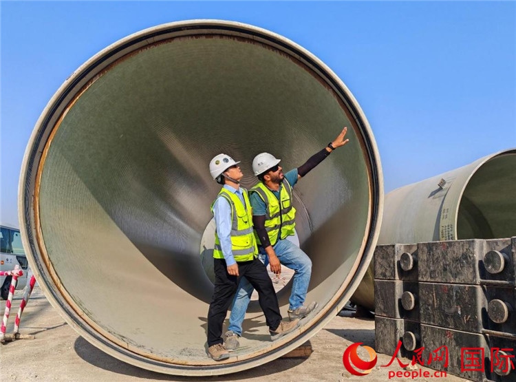 工作人員在察看輸水管情況。人民網(wǎng)記者 管克江攝