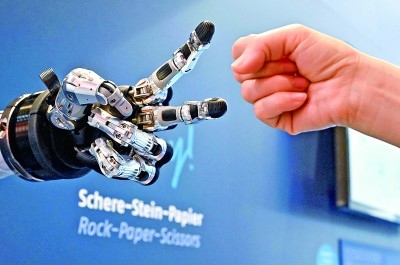 在德國(guó)漢諾威工博會(huì)上，參觀者與一款智能機(jī)器人進(jìn)行“石頭剪子布”游戲。新華社發(fā)