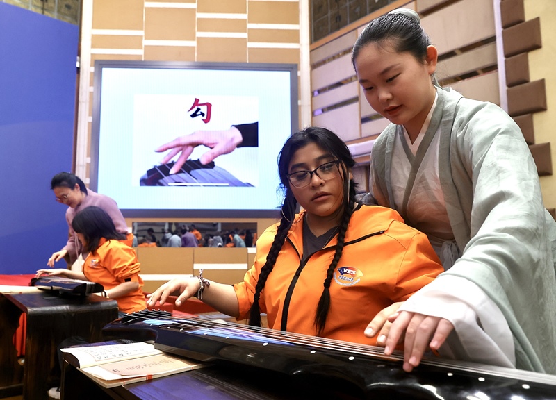 2024年3月20日，美國華盛頓州中學(xué)生代表團(tuán)北京大學(xué)交流活動在北京大學(xué)英杰交流中心舉行。圖為來自華盛頓州的中學(xué)生體驗古琴。