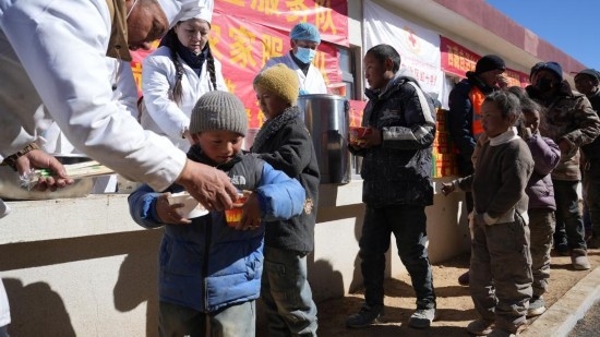 1月14日，廚師們正在給前來(lái)用餐的小朋友們打飯。新華社記者 邱星翔 攝