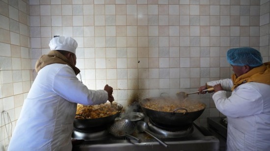 1月14日，服務(wù)隊(duì)的兩名廚師正在為村民們做午飯。新華社記者 邱星翔 攝