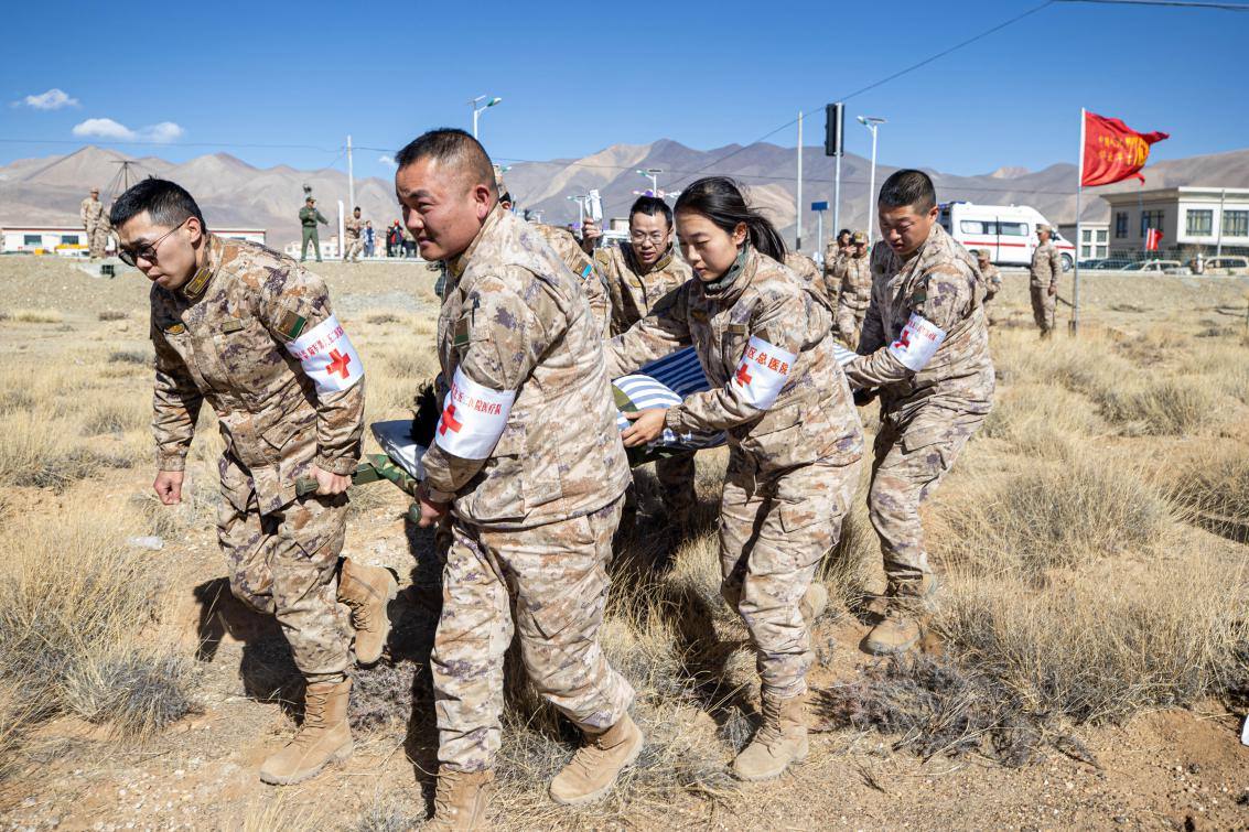 1月9日，日喀則定日縣長所鄉(xiāng)，西藏軍區(qū)總醫(yī)院醫(yī)療隊隊員將受傷村民用擔(dān)架從救護車準(zhǔn)備抬上直升機，轉(zhuǎn)運至拉薩的西藏軍區(qū)總醫(yī)院救治。人民日報記者張武軍攝