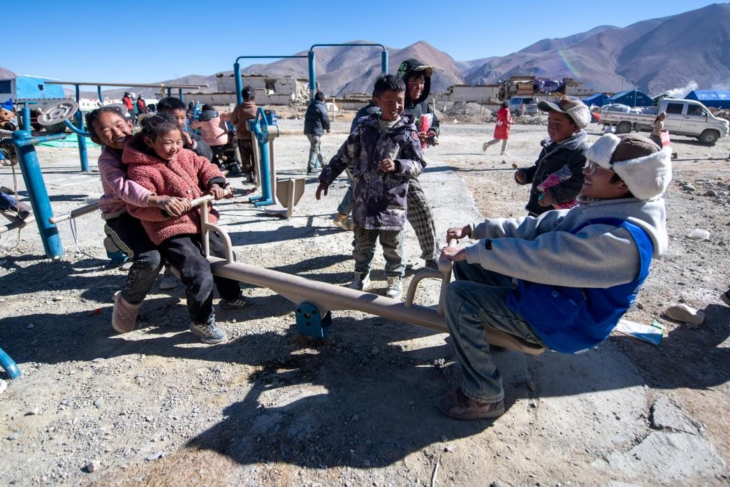 1月11日，在定日縣措果鄉(xiāng)塘仁村安置點，西藏星光社會工作服務(wù)中心志愿者和孩子們一起玩耍，進行災(zāi)后心理疏導(dǎo)。人民網(wǎng)記者 翁奇羽攝