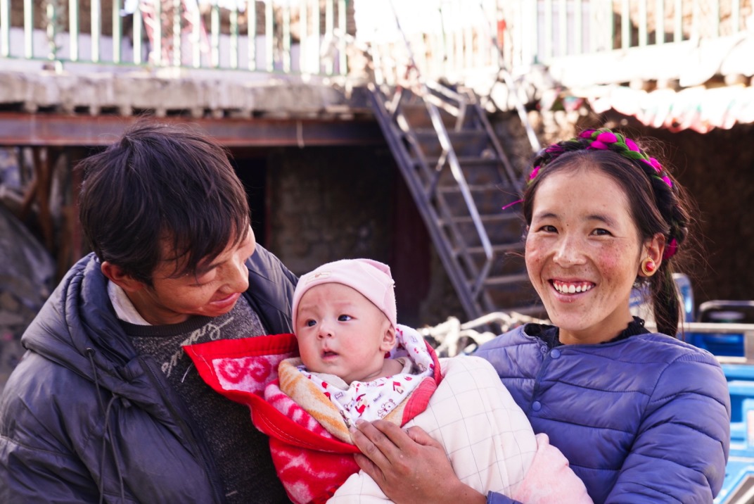 1月11日，在西藏日喀則市人民醫(yī)院，受災(zāi)群眾抱著自己在地震中受傷的孩子康復(fù)出院。人民日報記者徐馭堯攝