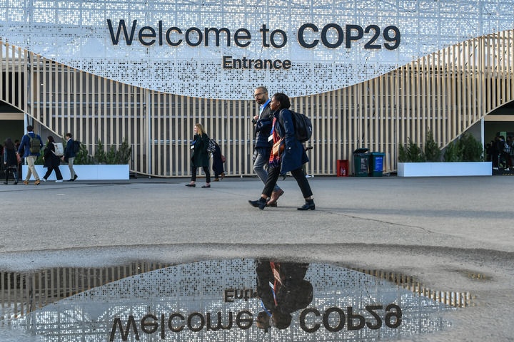 2024年11月15日，在阿塞拜疆首都巴庫(kù)，人們經(jīng)過(guò)聯(lián)合國(guó)氣候變化巴庫(kù)大會(huì)的會(huì)場(chǎng)。新華社記者 曹陽(yáng) 攝