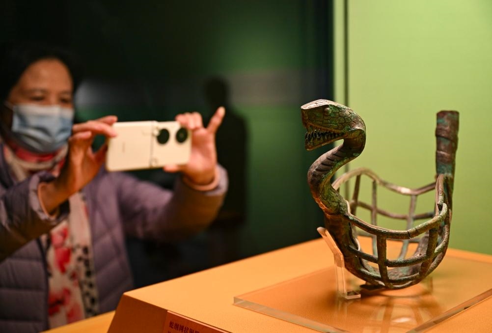 1月14日，觀眾在上海博物館蛇年迎春展拍攝展品蛇綱網(wǎng)狀銅器。新華社發(fā)（陳浩明攝）