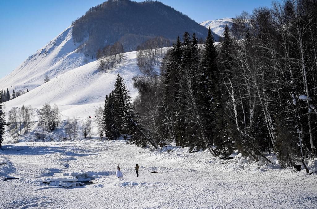 2024年2月5日，兩名游客在新疆阿勒泰地區(qū)布爾津縣禾木村拍照。新華社記者 馬鍇 攝