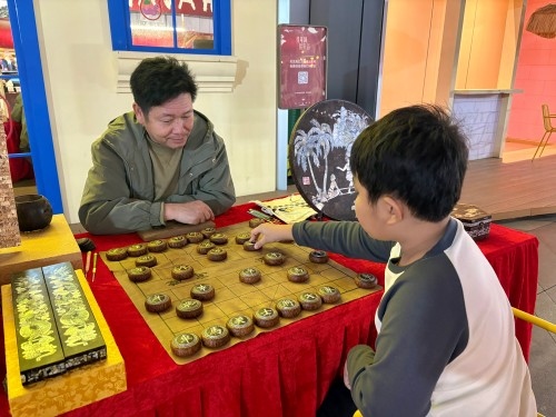 柯秋楓與市民下椰雕象棋。人民網 陳葉欣攝