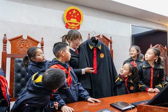 圖②：干警向同學(xué)們介紹法袍。