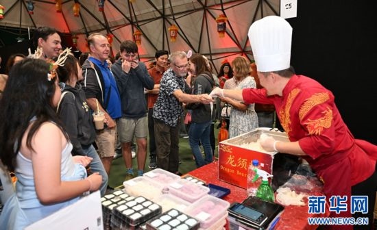 圖為游客在燈節(jié)現(xiàn)場(chǎng)購(gòu)買小吃。（圖片由奧克蘭中國(guó)文化中心提供）