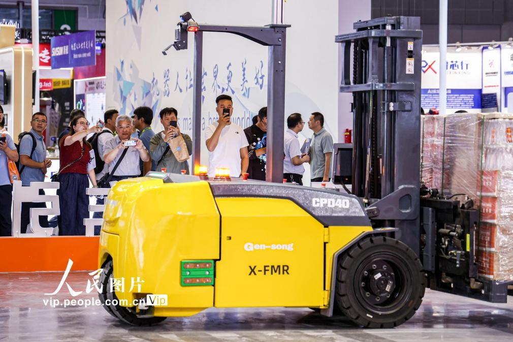 第24屆中國(guó)工博會(huì)現(xiàn)場(chǎng)，觀眾觀看叉取機(jī)器人作業(yè)演示。王初攝（人民圖片網(wǎng)）