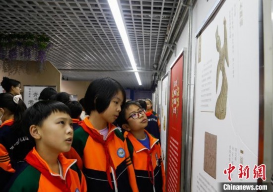 圖為學生參觀青海省博物館“1+3”主題流動展覽，了解木舞俑。中新社記者 馬銘言 攝