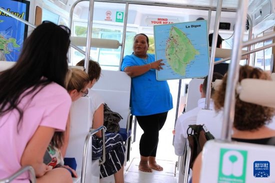 3月15日，一名導(dǎo)游在游艇上為游客介紹塞舌爾拉迪格島。新華社記者 董江輝 攝