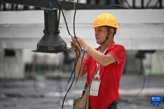 4月4日，工作人員在海南國際會(huì)展中心內(nèi)布設(shè)燈光。