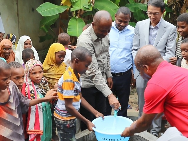 在日前舉行的安全供水工程揭牌儀式上，當(dāng)?shù)匦∨笥言诠┧c(diǎn)接水。 施亮攝