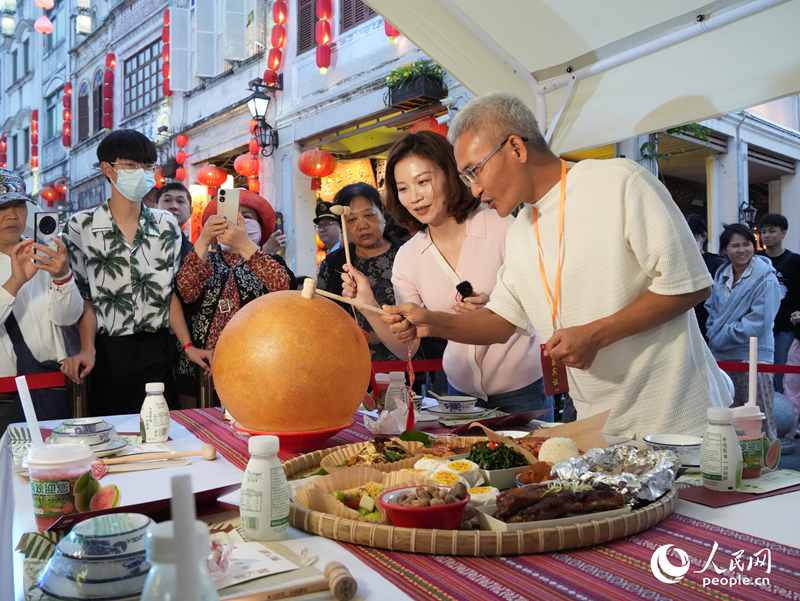 嘉賓品嘗海南傳統(tǒng)美食“煎堆”。人民網(wǎng)記者 張力洋攝