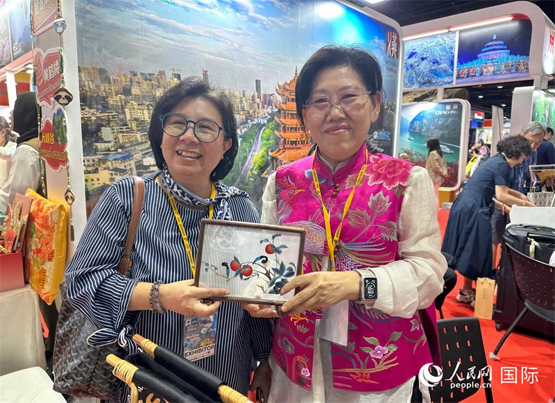 中國(guó)“大冶刺繡”傳承人劉小紅（右）參加泰國(guó)國(guó)際旅游展，向觀眾介紹中國(guó)非遺刺繡針法。人民網(wǎng)記者 簡(jiǎn)承淵攝