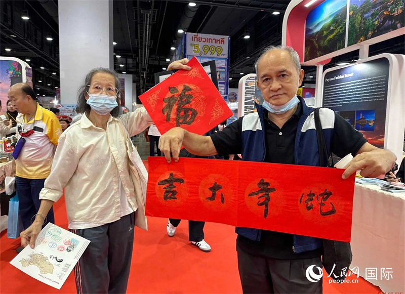 2025蛇年春節(jié)，泰國(guó)市民展示他們領(lǐng)到的華人手寫春聯(lián)。人民網(wǎng)記者 簡(jiǎn)承淵攝