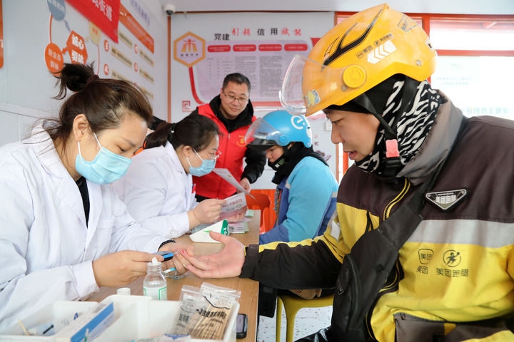 2025年3月5日，志愿者在山東省棗莊市市中區(qū)一工會(huì)驛站為外賣員免費(fèi)測量血糖。新華社發(fā)（王海楠攝）