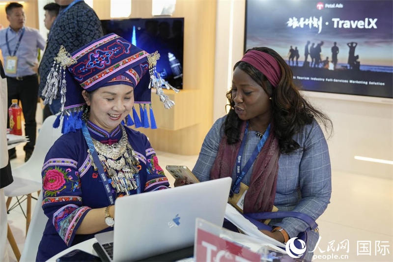 來(lái)自廣西的旅游業(yè)者同客戶交流。人民網(wǎng)塔里克·易卜拉欣攝
