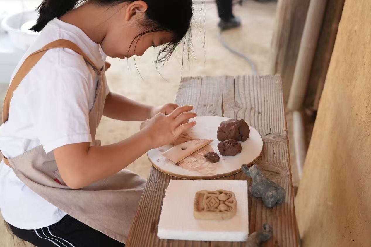 游客制作良渚特色陶藝品。良渚博物院供圖