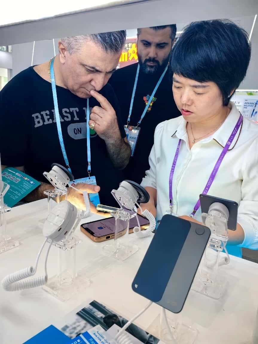 展臺(tái)工作人員向外商展示“AI TOP翻譯終端”。圖片來源：受訪者提供
