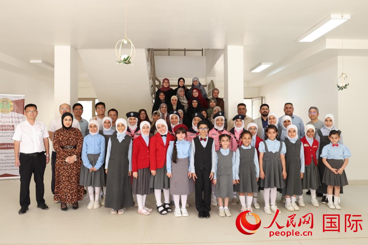 中國電建員工與阿爾穆塔?阿里卡特國際學(xué)校的師生及政府官員等合影。人民網(wǎng)記者 薛丹攝