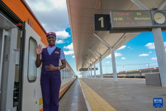 5月31日，在蒙內(nèi)鐵路內(nèi)羅畢站，一名乘務員在即將開往蒙巴薩的E2次列車旁等候乘客。新華社記者 楊光 攝
