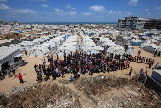 5月28日，人們在加沙城西部的沙提難民營等待領(lǐng)取救助食物。新華社發(fā)（里澤克·阿卜杜勒賈瓦德攝）