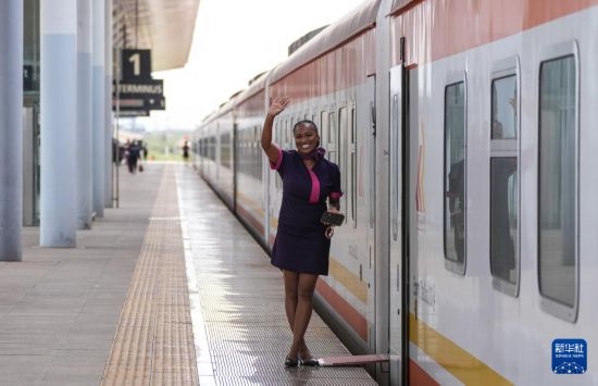 5月31日，在蒙內(nèi)鐵路內(nèi)羅畢站，一名乘務員在即將開往蒙巴薩的E2次列車旁等候乘客。新華社記者 李亞輝 攝