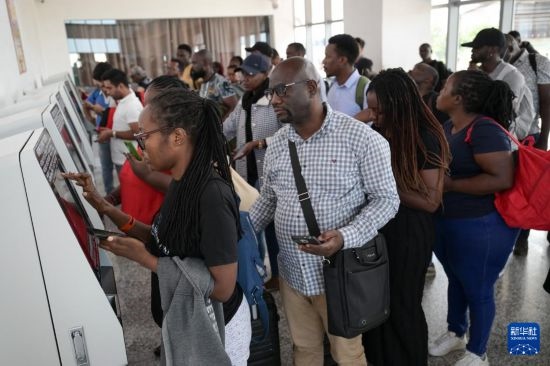 5月31日，在蒙內(nèi)鐵路內(nèi)羅畢站，乘客在自助取票機前排隊取票。新華社記者 楊光 攝