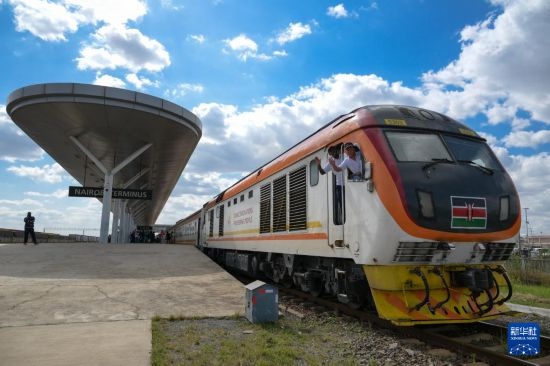 5月31日，在蒙內(nèi)鐵路內(nèi)羅畢站，機車駕駛員蔣立平（右）和博爾在即將開往蒙巴薩的E2次列車上揮手致意。新華社記者 楊光 攝