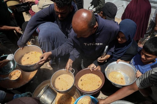 5月28日，人們在加沙城西部的沙提難民營領(lǐng)取救助食物。新華社發(fā)（里澤克·阿卜杜勒賈瓦德攝）