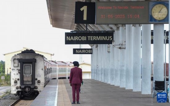 5月31日，在蒙內(nèi)鐵路內(nèi)羅畢站，工作人員目送開往蒙巴薩的E2次列車駛離站臺。新華社記者 李亞輝 攝